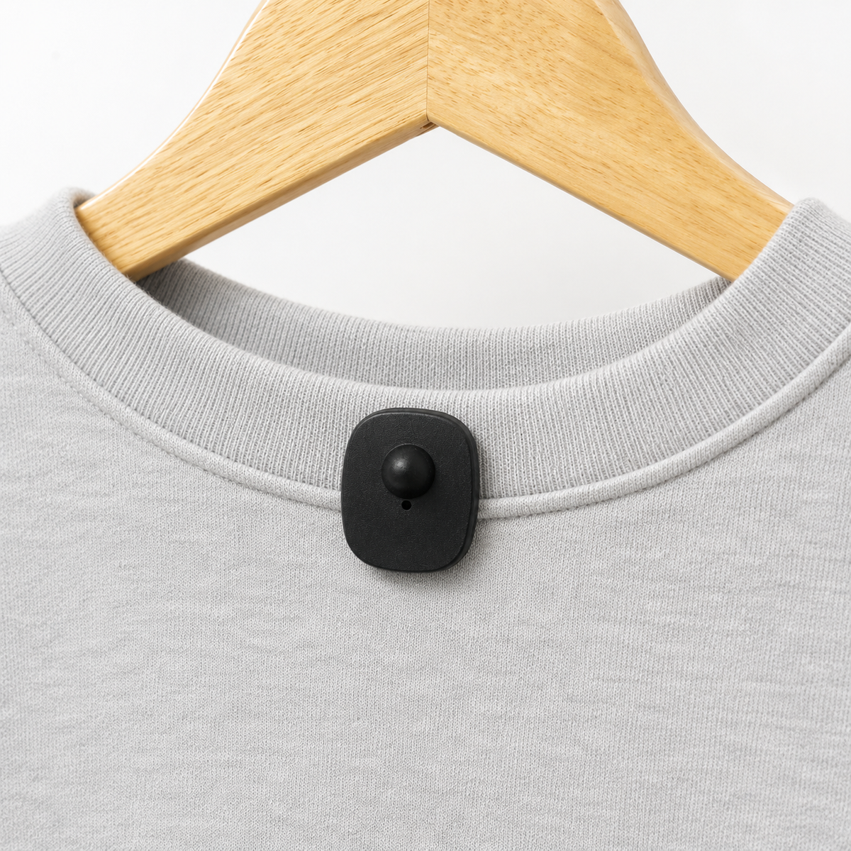 Close-up of INEO Mini Rectangular Tag RF 8.2 MHz secured to a grey sweatshirt